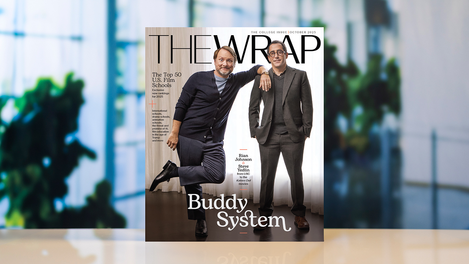 Two men wearing suits stand next to each other on the October 2025 cover of TheWrap magazine. The headline “Top 50 US Film Schools” is next to them.