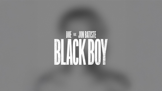 A blurred outline of a young man on a gray background with the words DOE feat. Jon Batiste Black Boy overlaid in white text.