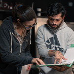 Deborah Walters helps student script supervisor Ryan Bessette with script on set