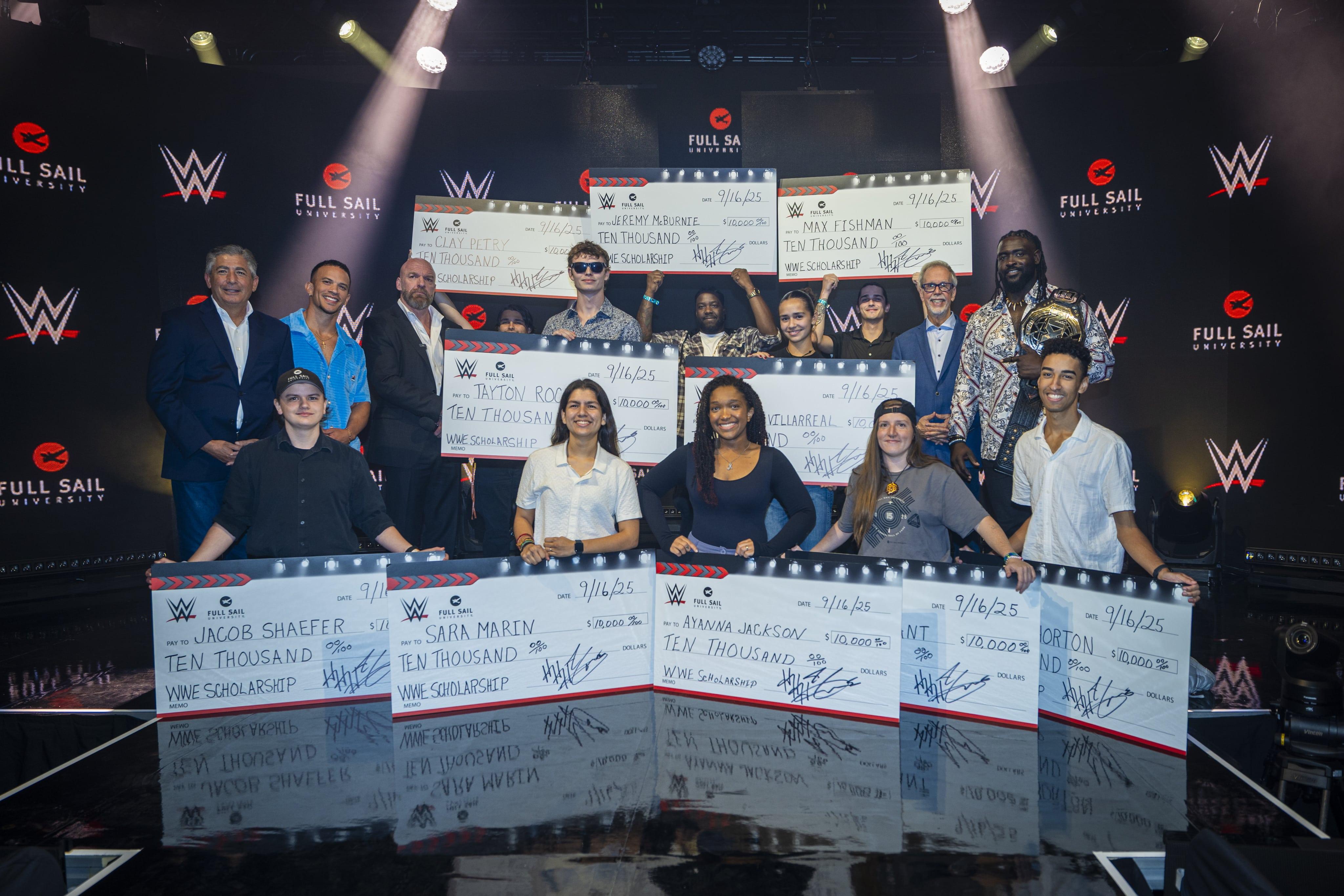 Full Sail students and WWE superstars celebrate as scholarship winners hold $10,000 checks on stage at ‘NXT Homecoming.’