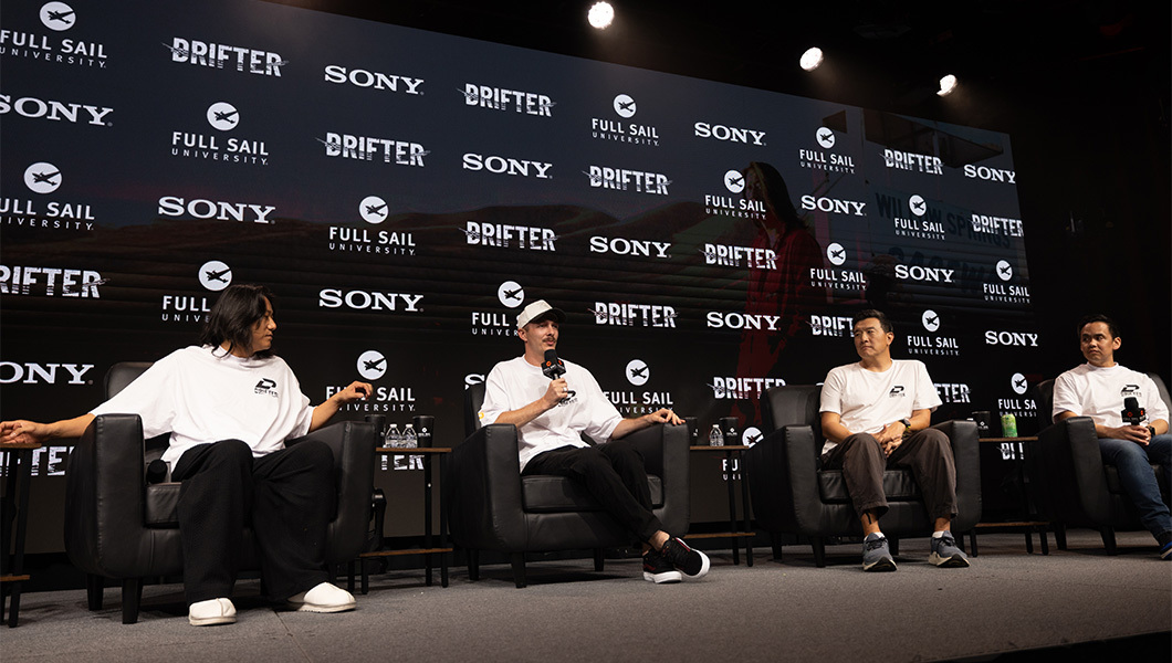 Sung Kang and company sit onstage during a panel discussion, with Full Sail, Sony, and Drifter logos displayed behind them.