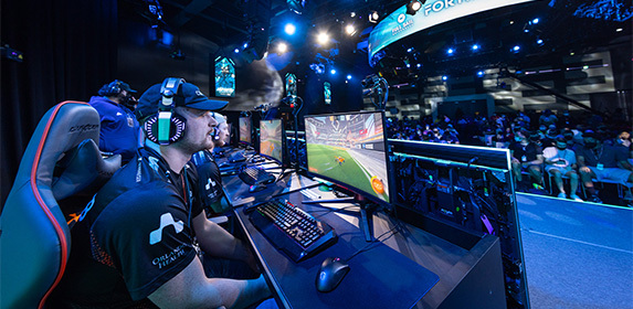 Full Sail Armada athletes play 'Rocket League' on stage in front of a crowd in the Full Sail University Orlando Health Fortress.
