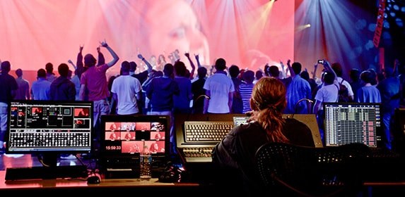 A Live Event student uses audio and light controls to transform a live concert into an experience for attendees.
